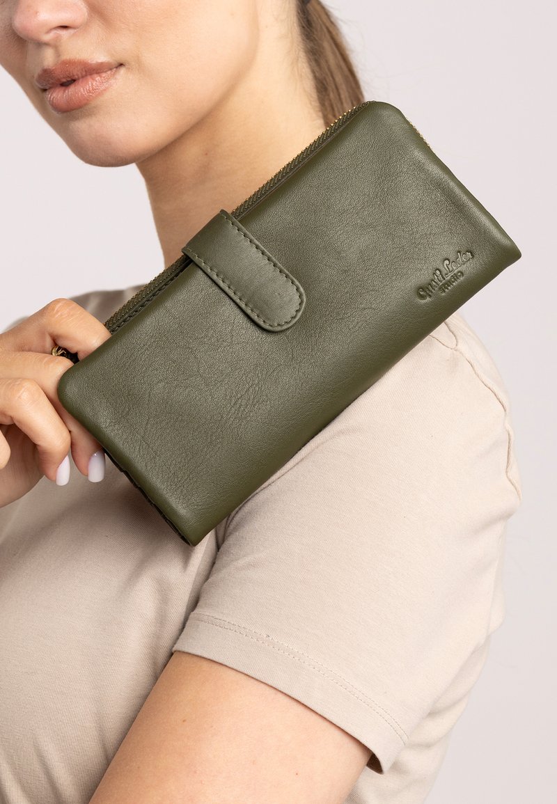 Green leather wallet with a smooth texture and snap closure. Features a zip around the edge and logo embossed on the front.