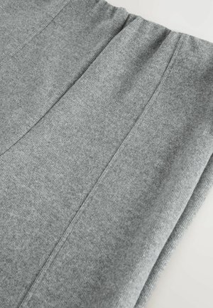 Sivé jogger nohavice z elastického materiálu s jemnou textúrou, s širokým elastickým pásom a vertikálnymi švami prebiehajúcimi po nohách.