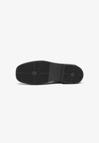 Sola de sapato preta com borracha texturizada, apresentando um padrão de diamante e ranhuras distintas para tração. Design plano, minimalista e funcional.