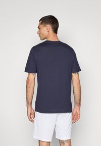 Marine t-shirt van katoen, met een ronde hals en korte mouwen. De stof lijkt soepel en past dicht tegen het lichaam.