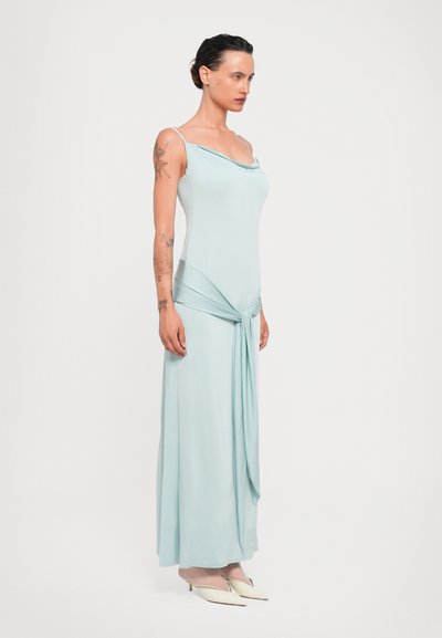 Lichtblauwe maxi-jurk van zacht materiaal, met dunne banden en een geknoopte taille. Soepele textuur met een vloeiende silhouet.