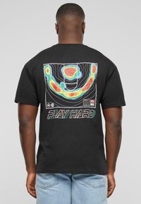 Sort bomulds T-shirt med et farverigt grafisk design på ryggen med konturlinjer og tekst, der står "PLAY HARD."