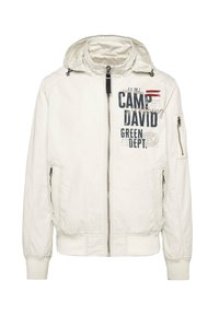 White hooded jacket with zip closure, featuring front and side pockets. Includes printed text and accents in navy and red. Smooth texture.