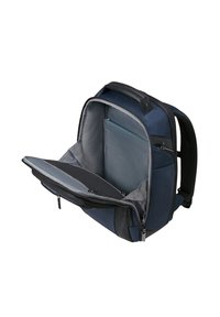 Zaino blu navy con scomparto imbottito per laptop aperto, che mostra tasche interne e rivestimento grigio, isolato su sfondo bianco.