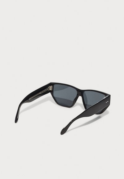 Lunettes de soleil noires avec une monture angulaire et géométrique ; verres teintés gris ; finition brillante ; branches fines avec de petits accents en métal.