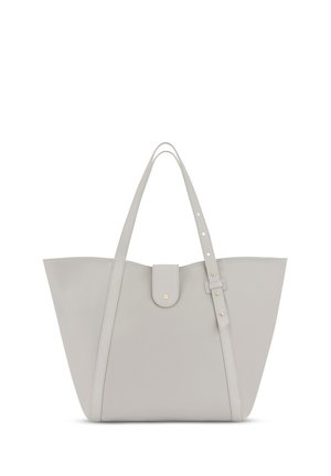 Lichtgrijze totebag gemaakt van glad materiaal, met twee lange handvatten, een klep-sluiting en accenten van goudkleurig hardware.