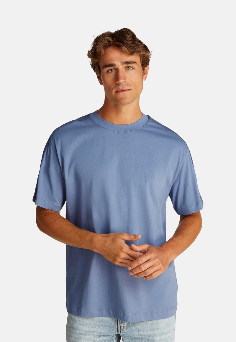 Camiseta de manga corta para hombre en algodón de color azul claro, con cuello redondo, corte relajado, textura suave y diseño sin adornos.
