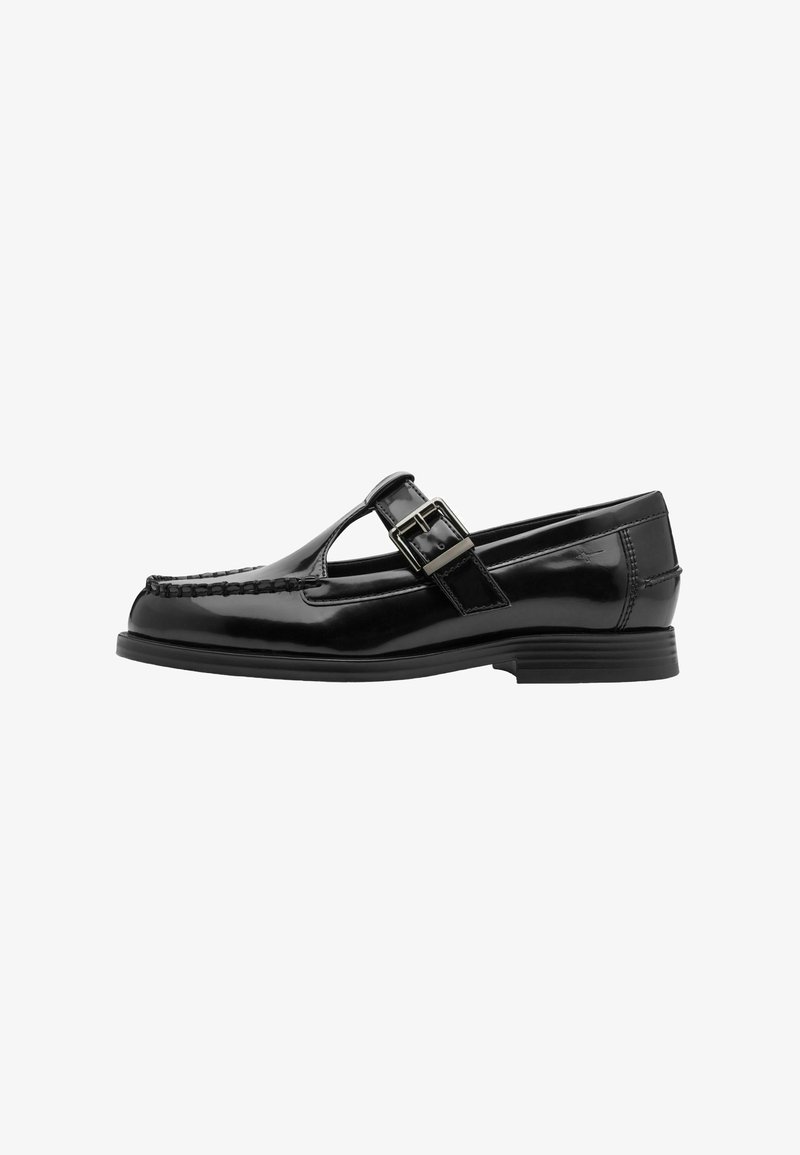 Mocassins en cuir verni noir avec une bride en T, un détail boucle, et un talon bas. Présentent un bout renforcé cousu et une finition lisse et brillante.
