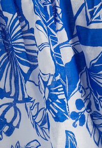 Tela azul y blanca con un patrón floral que incluye hojas y bayas, hecha de un material ligero y texturizado.