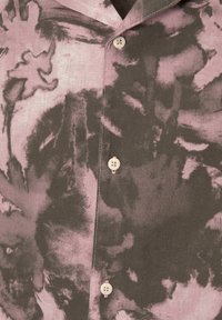 Camicia in lino a maniche corte con un motivo astratto rosa e grigio, con una texture morbida e bottoni leggeri lungo la parte anteriore.