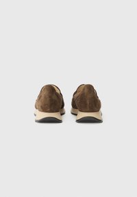 Brown suede shoes with a smooth beige sole and black accents, featuring a rounded design and subtle stitching detail.