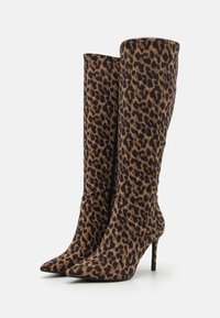 Bottes montantes imprimé léopard avec un bout pointu, un talon aiguille et un tissu à texture lisse. Détail de fermeture éclair sur le côté pour un enfilage facile.