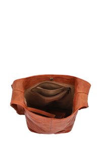 Brown leather tote bag with an open top, featuring interior pockets and a textured finish. Stylized stitching along the edges.
