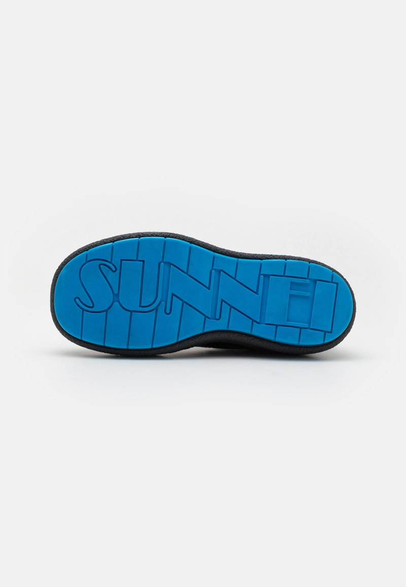 Suola di sneaker nera con superficie strutturata e fondo in gomma blu, con la parola "SUNNEI" in rilievo.