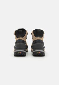 Scarponi da trekking marroni e neri con materiale testurizzato, alto supporto alla caviglia e accenti multicolori sulla suola. Design rinforzato per punta e tallone.