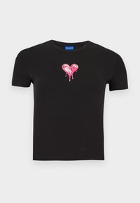Camiseta negra de algodón con mangas cortas que presenta un gran gráfico de un corazón rosa brillante con gotas cayendo desde el centro.