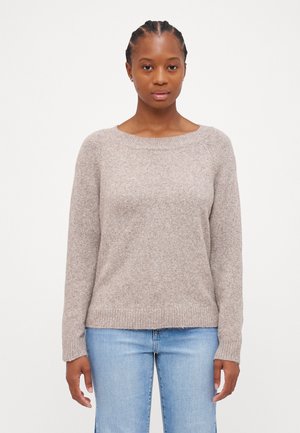 Hellbrauner, weicher Pullover mit Rundhalsausschnitt, langen Ärmeln, gerippten Bündchen und Saum, getragen über hellblauen Jeans.