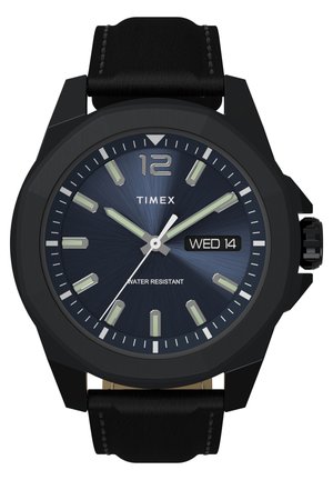 Montre analogique noire avec un cadran rond, un cadran texturé bleu, des index lumineux, un affichage de la date et un bracelet en cuir noir ; résistante à l'eau.