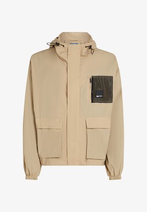 Beige színű, könnyű kabát, kapucnival, bal oldalon hálós zsebbel, két elülső zsebbel és gumírozott mandzsettákkal.