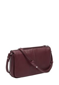 Bordowa skórzana torba na ramię z zamkiem błyskawicznym, charakteryzuje się smukłym designem, regulowanym paskiem oraz subtelnym detalem przeszycia z przodu.