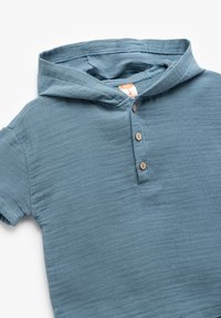 Lichtblauwe hoodie met korte mouwen en een knoopsluiting, gemaakt van een zachte textuurstof. De hoodie heeft een buidelzak en een relaxte pasvorm.