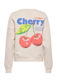 Sweatshirt crème avec un grand graphique de deux cerises et une feuille au dos, avec le mot "Cherry" en texte bleu gras.