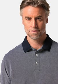 Szara koszulka polo z granatowym kołnierzykiem, z guziczkami oraz teksturowanym wzorem materiału. Slim fit z krótkimi rękawami i dyskretnym designem.