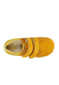 Sneaker gialla in pelle scamosciata con due cinturini in Velcro, caratterizzata da una punta rotonda, dettagli in tessuto testurizzato e una suola in gomma bianca.