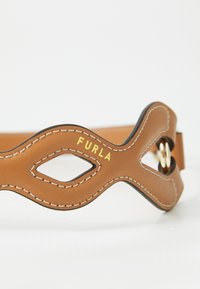 Cintura in pelle marrone con design a onda, dettagli intagliati, cuciture bianche e logo dorato "Furla". Presenta un particolare fermo rotondo.