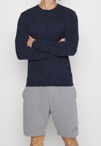 Námořnická položená košile s texturovanou tkaninou a kulatým výstřihem, doplněná šedými šortkami s vyšitým logem GAP.