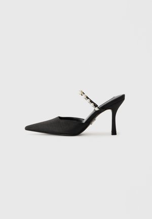 Sandal com salto em cetim preto, com bico apontado, adornada com uma tira de strass e pérolas, apresentando um salto agulha.