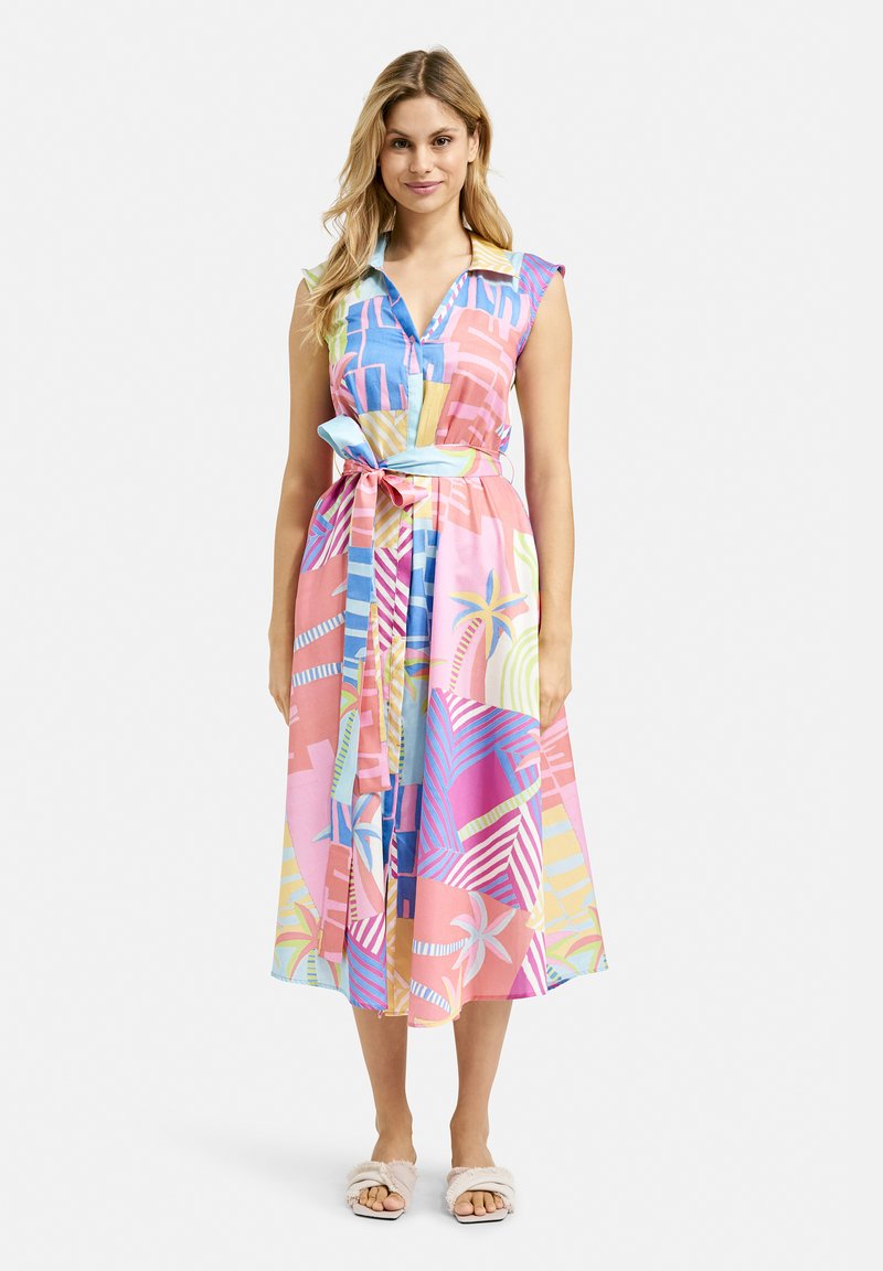 Colorful, sleeveless dress with a collar, featuring a tropical geometric pattern in pink, blue, and yellow. Includes a tied waist belt.