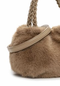 Ronde, padded handtas in tan nepbont met een gladde tan leren schouderband. Beschikt over een gevlochten bandontwerp met een subtiele glans.