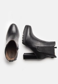 Czarne skórzane botki za kostkę z szpiczastym noskiem, teksturowanym bocznym panelem oraz masywnym obcasem typu słupek z antypoślizgową podeszwą; zapięcie na zamek po jednej stronie.