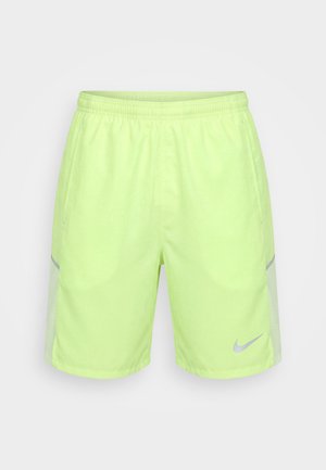 Pantaloncini sportivi giallo-verdi neon con vita elastica, tasche laterali, pannelli laterali riflettenti e piccolo logo Nike riflettente sulla gamba sinistra.
