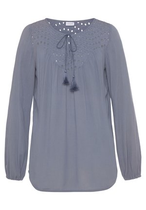 Light blue long-sleeve blouse with a round neckline, featuring decorative eyelet details and tassel ties at the front. Made from lightweight fabric.