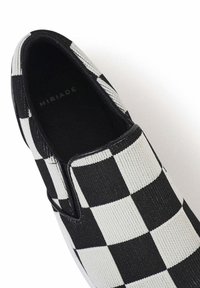Scarpa slip-on a scacchi bianco e nero realizzata in tessuto intrecciato, con punta arrotondata e rivestimento interno nero con dettaglio logo.