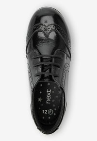 Schwarzer Lacklederschuh mit dekorativen Perforationen, runder Zehenform und Schnürverschluss. Das Innere hat ein Sternenmuster; Größe angegeben als 12 F.