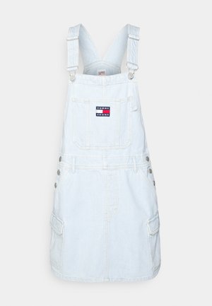 Jasnoniebieska sukienka ogrodniczka z denimu z regulowanymi ramiączkami, przednią kieszenią z naszywką z logo Tommy Jeans, bocznymi guzikami i kieszeniami w stylu cargo.