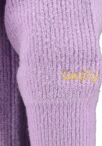 Ärmel eines fliederfarbenen gestrickten Pullovers mit dem gelb gestickten Wort „Simply“ in der Nähe des Ellbogenbereichs.