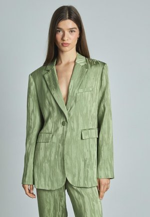 Groene textuurblazer met een enkele knoop, notch-lapels en twee voorzakken. Glad stof met een subtiel patroon, op maat gesneden pasvorm.