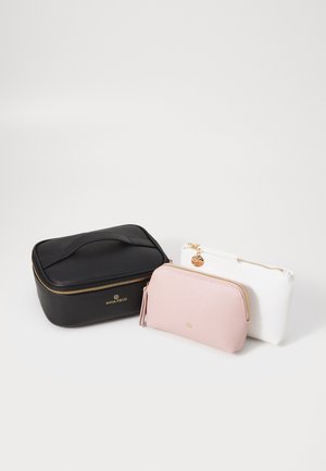 Conjunto de tres bolsos: un estuche rectangular negro con cremallera dorada y asa, un bolso de cremallera rosa y un bolso de cremallera blanco con detalles dorados.
