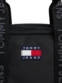 Borsa nera in nylon con chiusura a zip. Il davanti mostra un logo ricamato rettangolare blu, bianco e rosso con la scritta "TOMMY JEANS."