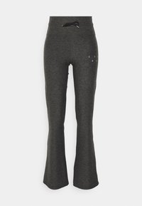 Grå utsvängda träningsbyxor i mjukt tyg, med elastisk dragsko i midjan och ett litet tryckt detalj på sidan.