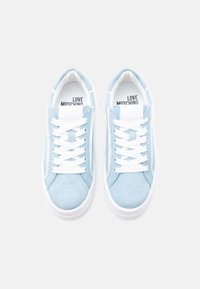 Ανοιχτό μπλε σουέντ αθλητικά παπούτσια με άσπρα κορδόνια, λευκή ελαστική σόλα και την ένδειξη "LOVE MOSCHINO" στην εσωτερική σόλα. Στρογγυλερός σχεδιασμός μύτης.