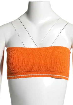 Haut bandeau texturé orange avec de fines rayures blanches le long du bord inférieur, présenté sur un torse de mannequin blanc.