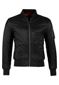Chaqueta bomber negra de tejido suave, con cierre de cremallera en el frente, cuello y puños acanalados, y un bolsillo con cremallera en el brazo izquierdo. Forro rojo en el interior.