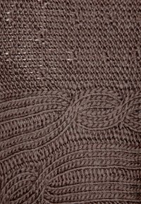 Dzianina o średnim brązowym kolorze, z teksturowanymi, przeplatanymi wzorami i liniami, o miękkim, puszystym wyglądzie na całej powierzchni.