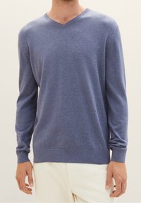 Maglione blu a scollo a V realizzato in tessuto morbido, con maniche lunghe, orlo aderente e trama delicata. Senza motivi visibili o accessori.