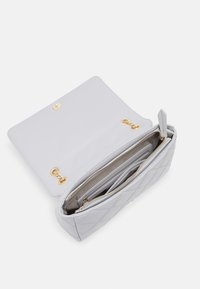 Borsa in pelle trapuntata grigio chiaro con chiusura dorata, dotata di un ampio interno e diversi scomparti per l'organizzazione.